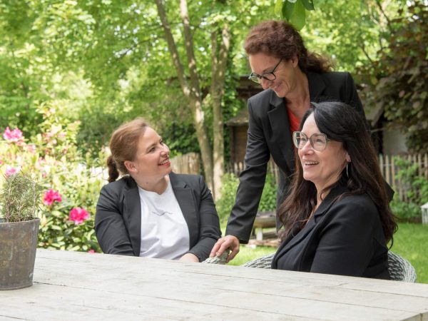 Das Bild zeigt Petra Winterscheid mit zwei Mitarbeitern am reden